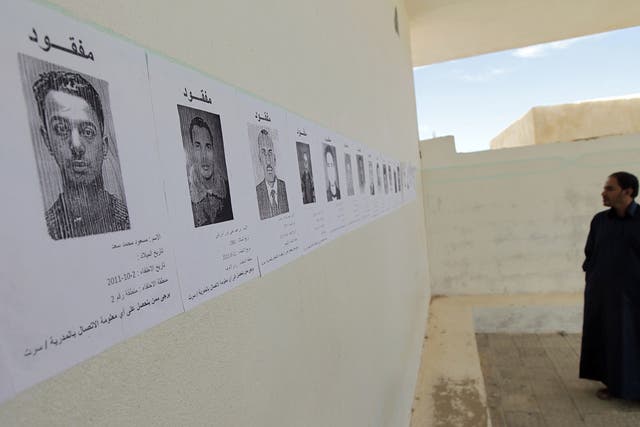 Disappeared:
Pictures of
people who went
missing under
Gaddafi are
pasted to a wall
in Sirte