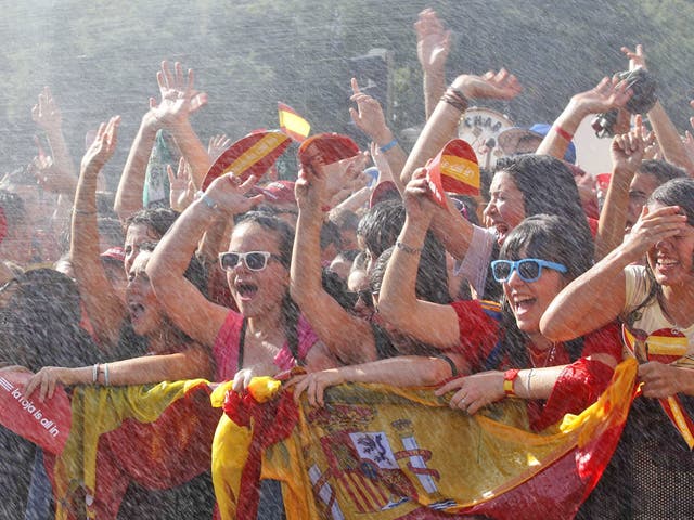 Supporters are sprayed with water as they wait for Spain’s
football team to arrive at Plaza Cibeles in Madrid yesterday