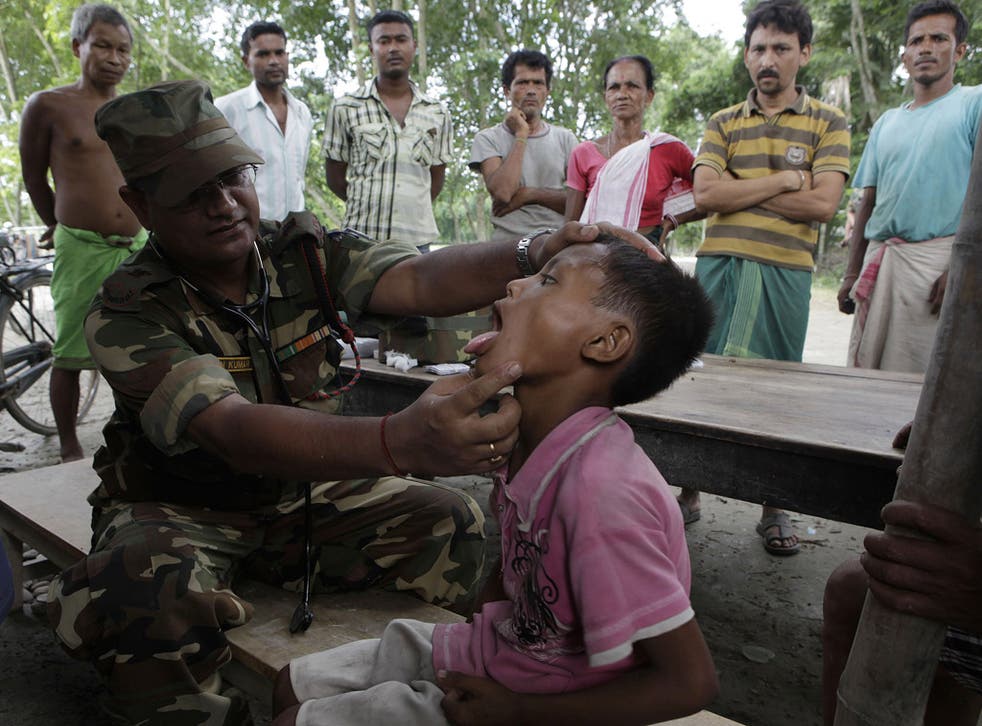 An army doctor checks a child in the village of Phateki, in India's north-eastern Assam state, which was hit by floods this week