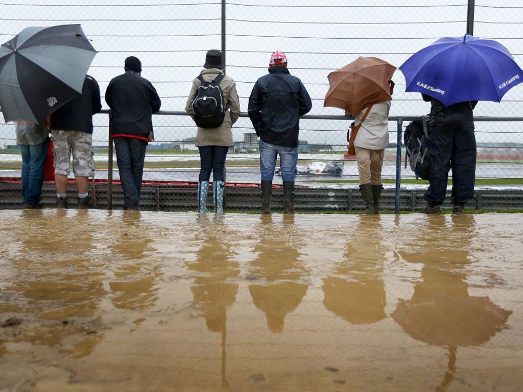 It's wellies and brollies galore as hardy fans watch a practice session at sodden Silverstone