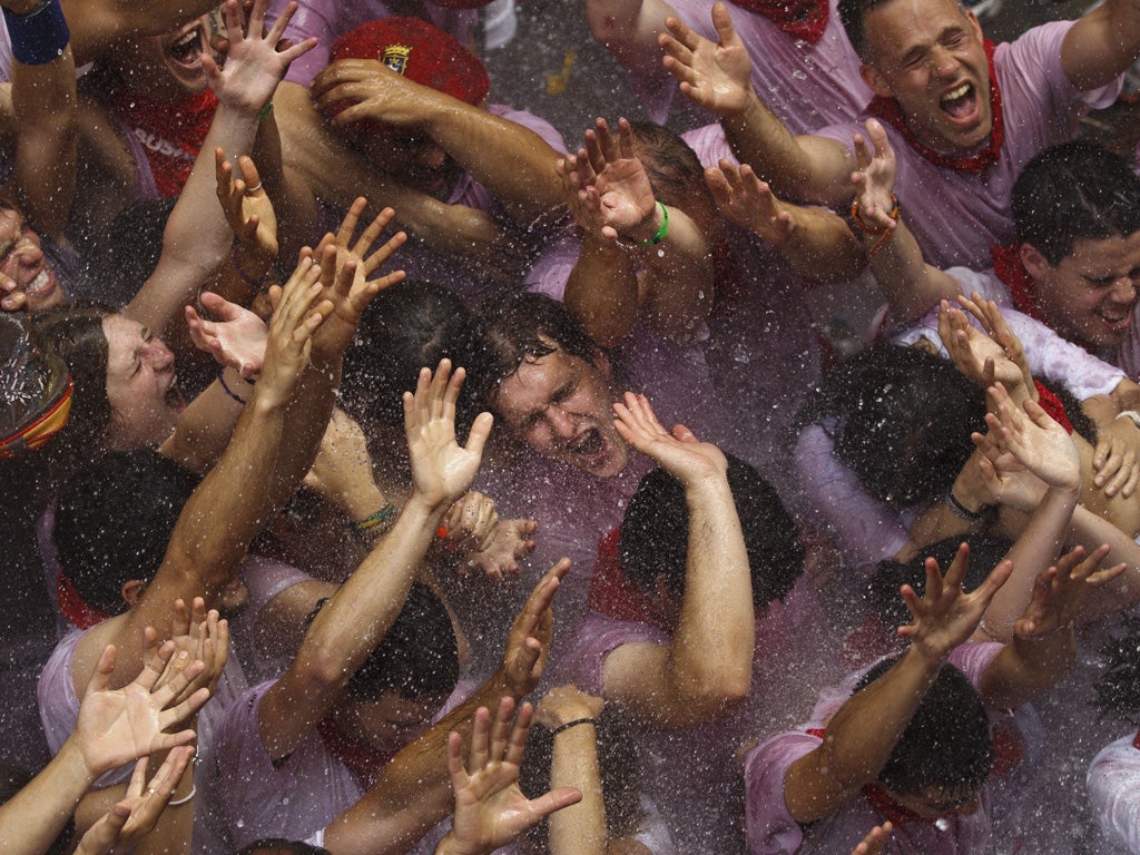 Revellers being sprayed with water after the official opening of the San Fermin festival in Pamplona, Spain