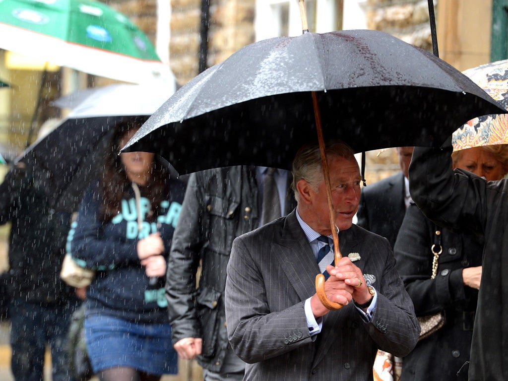 Prince Charles feels the full force of the rain as he visits flood victims