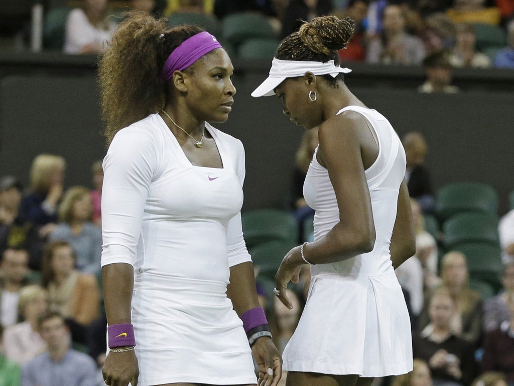 Williams' sisters Serena and Venus talk tactics during their game against Czech Republic's Andrea Hlavackova and Lucie Hradecka