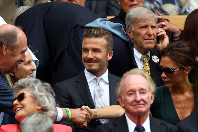 Rod Laver sits in front of David Beckham yesterday