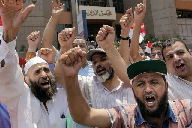 Supporters of president Mohammed Morsi chant slogans during a demonstration in front of Egypt's state council in Cairo yesterday