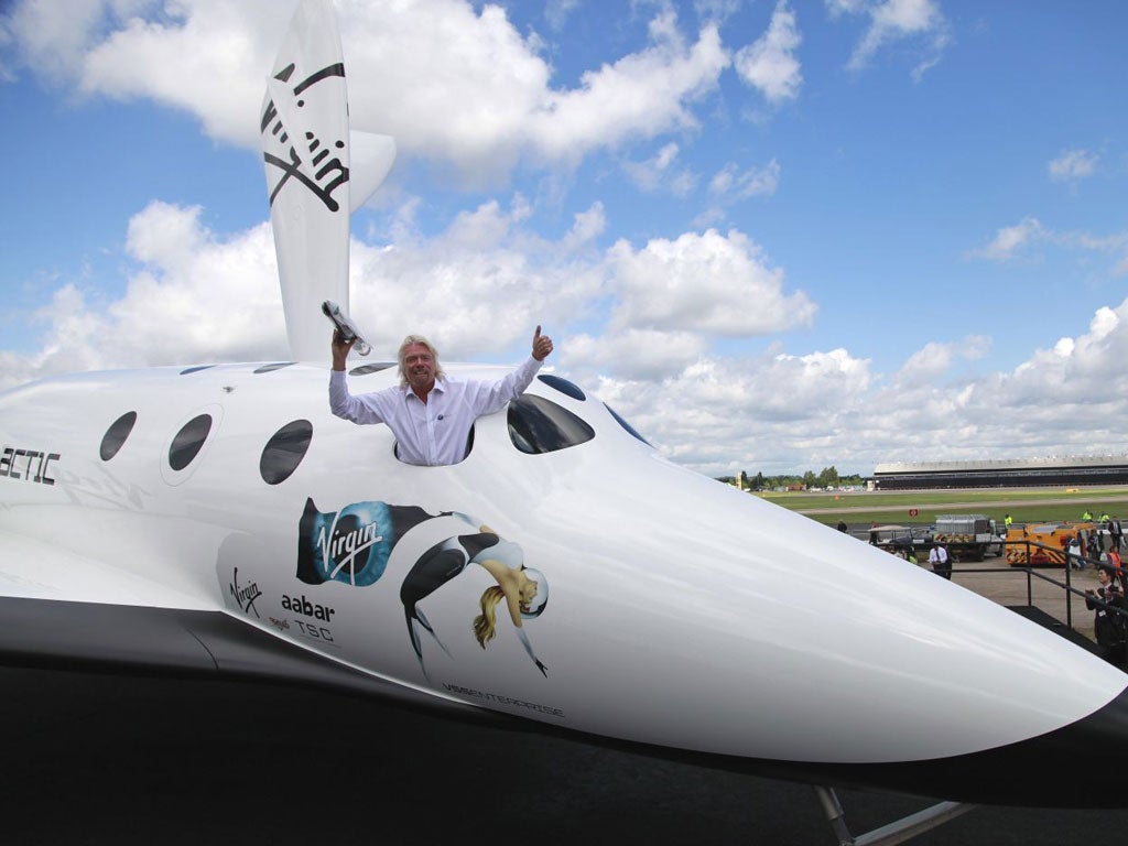 British billionaire Richard Branson poses for the photographers in the window of a replica of the Virgin Galactic