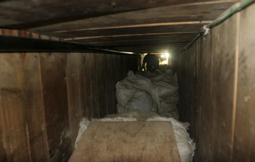 A reporter crawls through one of the tunnels discovered under a sink in a warehouse in Tijuana