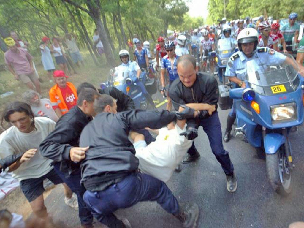 Police remove anti-globalisation demonstrators holding up the 10th
stage of the 2003 Tour de France between Gap and Marseilles