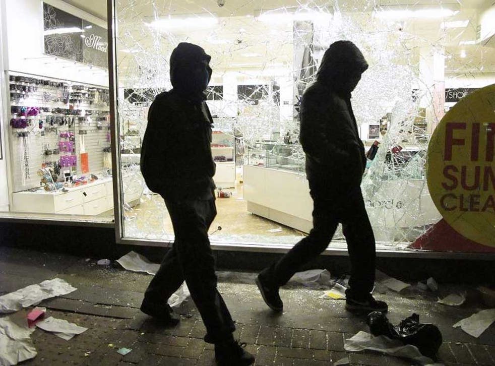 The price of not caring: Youths walk past a looted Debenhams store during the London riots in 2011 Peter