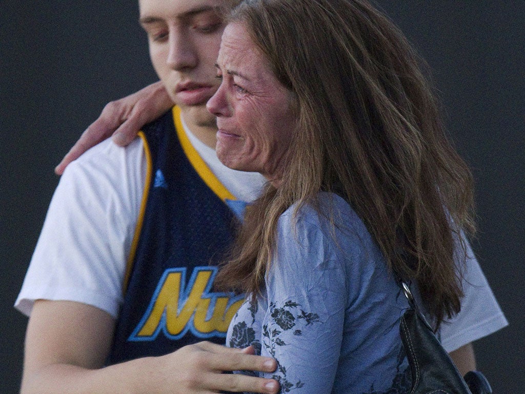 A woman is comforted outside the cinema