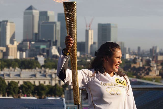 Natasha Sinha, 15, holds the Olympic torch aloft at the Observatory in Greenwich Park