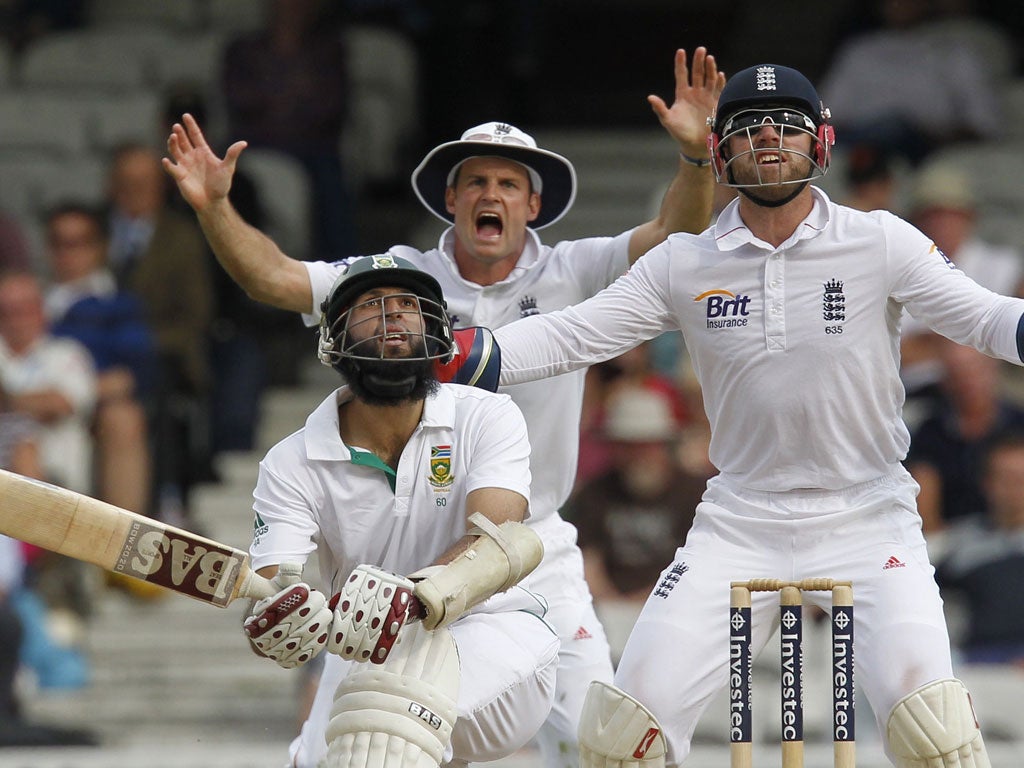 Andrew Strauss and England's wicketkeeper Matt Prior react as Hashim Amla of South Africa hits the ball
