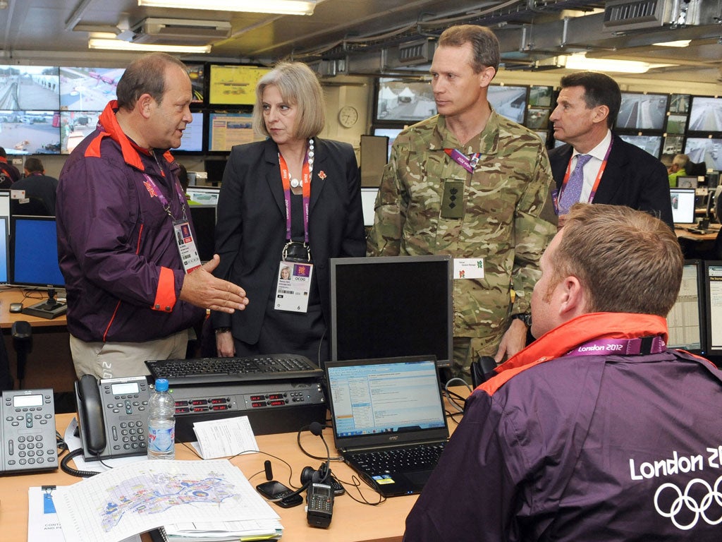 Starters' orders: Home Secretary Theresa May speaks with (left to right) Olympic Park general manager Clive Stevens, military representative Colonel Gary Wilkinson and LOCOG chairman Lord Coe in the security control room