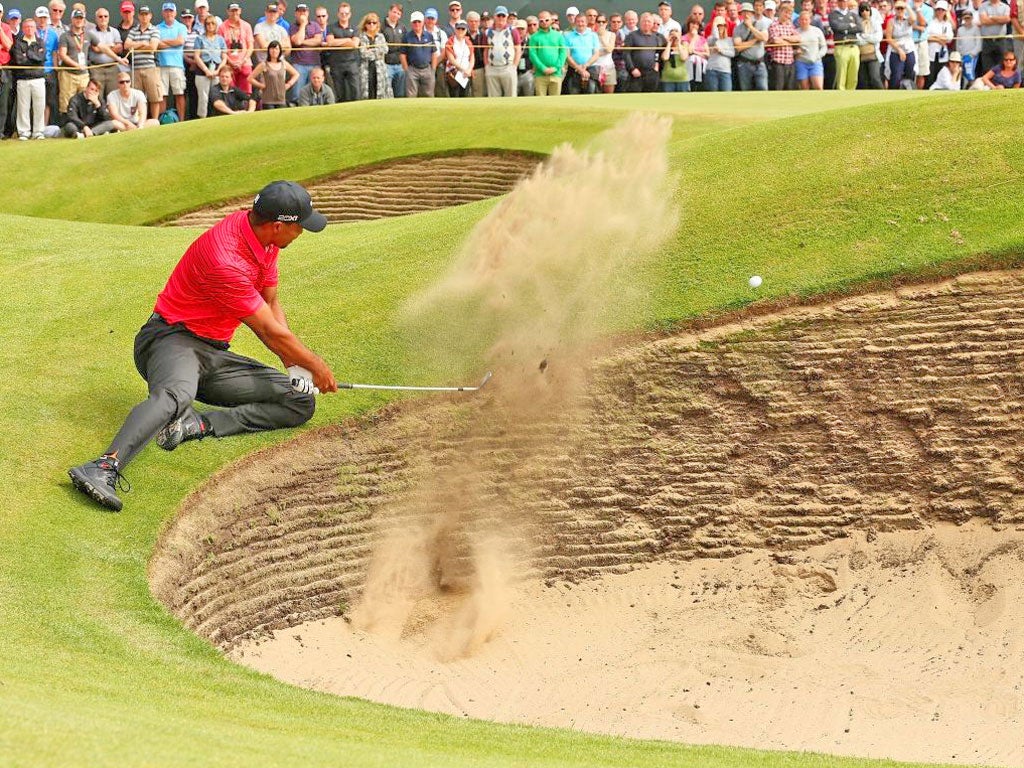 Tiger Woods plays out of a bunker on the sixth hole