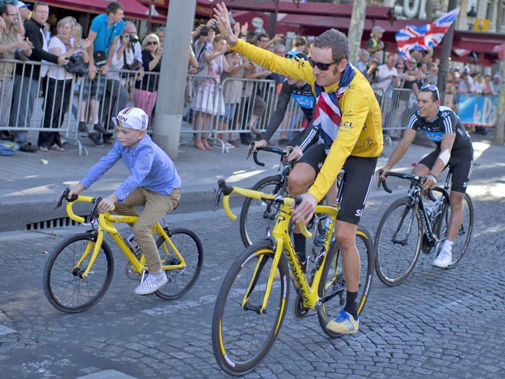 Tour de France 2012 winner, British Bradley Wiggins, rides with his son Ben during his parade at the end of the 120 km and last stage of the race