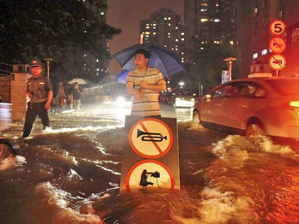 China's capital is shaken by the heaviest rain in six decades as it leaves 37 people dead