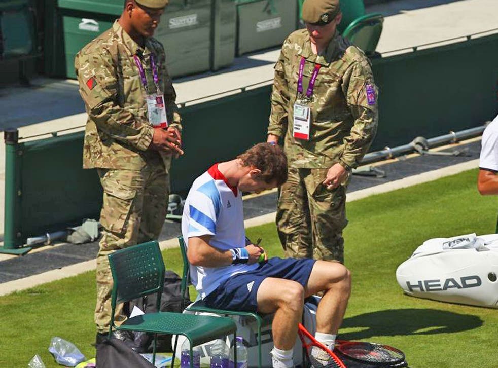 Picture of the day: Andy Murray proves a big hit with a pair of soldiers during a break from training at Wimbledon yesterday,
signing a ball for the standing security guards. The Scot was returning to the scene of his final defeat by Roger Federer just ov
