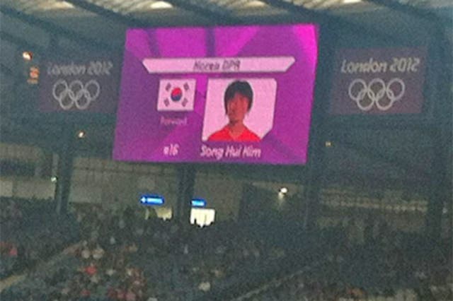 The South Korean flag is displayed alongside one of North Korea's players on the big screen