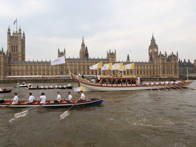 The Queen's rowbarge 'Gloriana' carries the Olympic flame along the river Thames