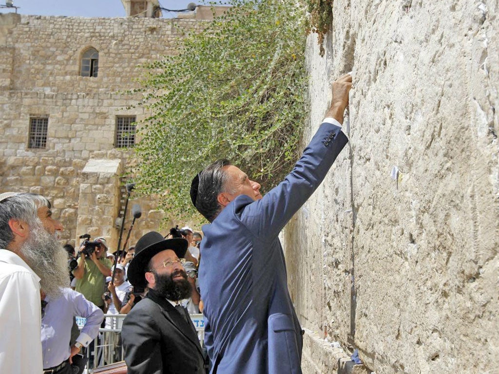 Mitt Romney places a message in the ancient stones of the Western Wall in Jerusalem’s Old City yesterday