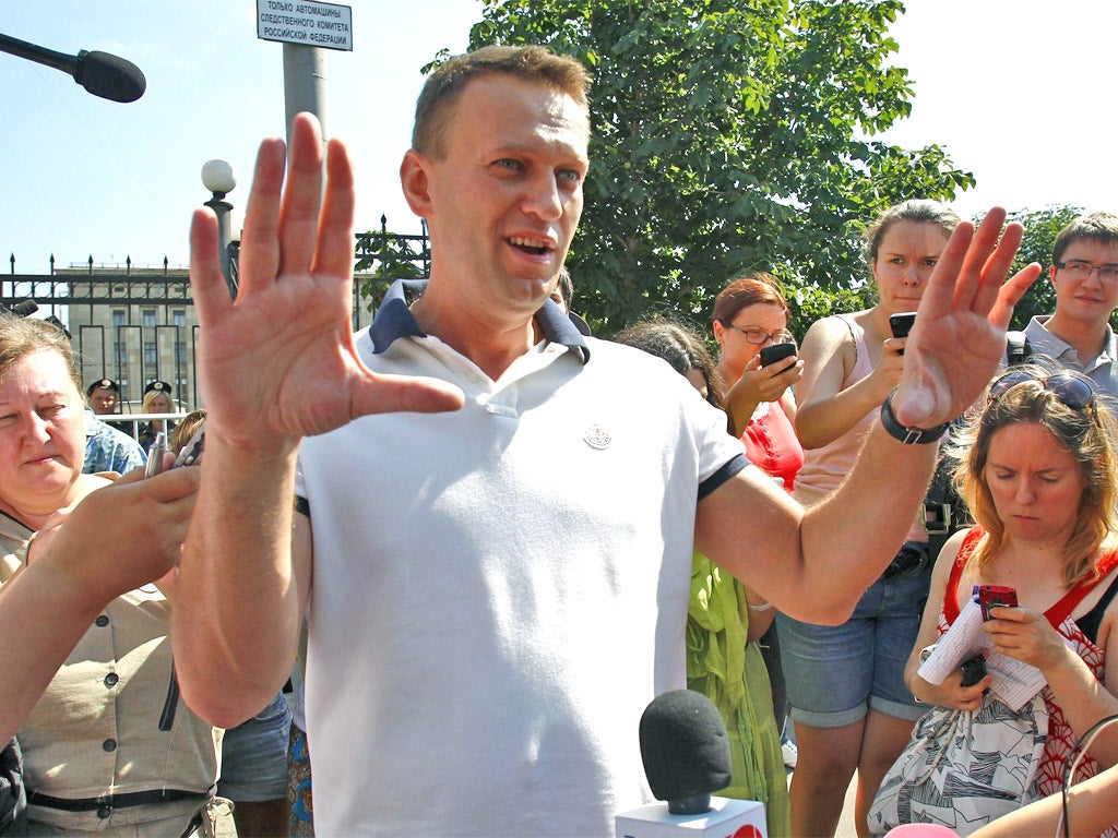 Alexei Navalny gestures to journalists after leaving the Investigative Committee HQ in Moscow yesterday