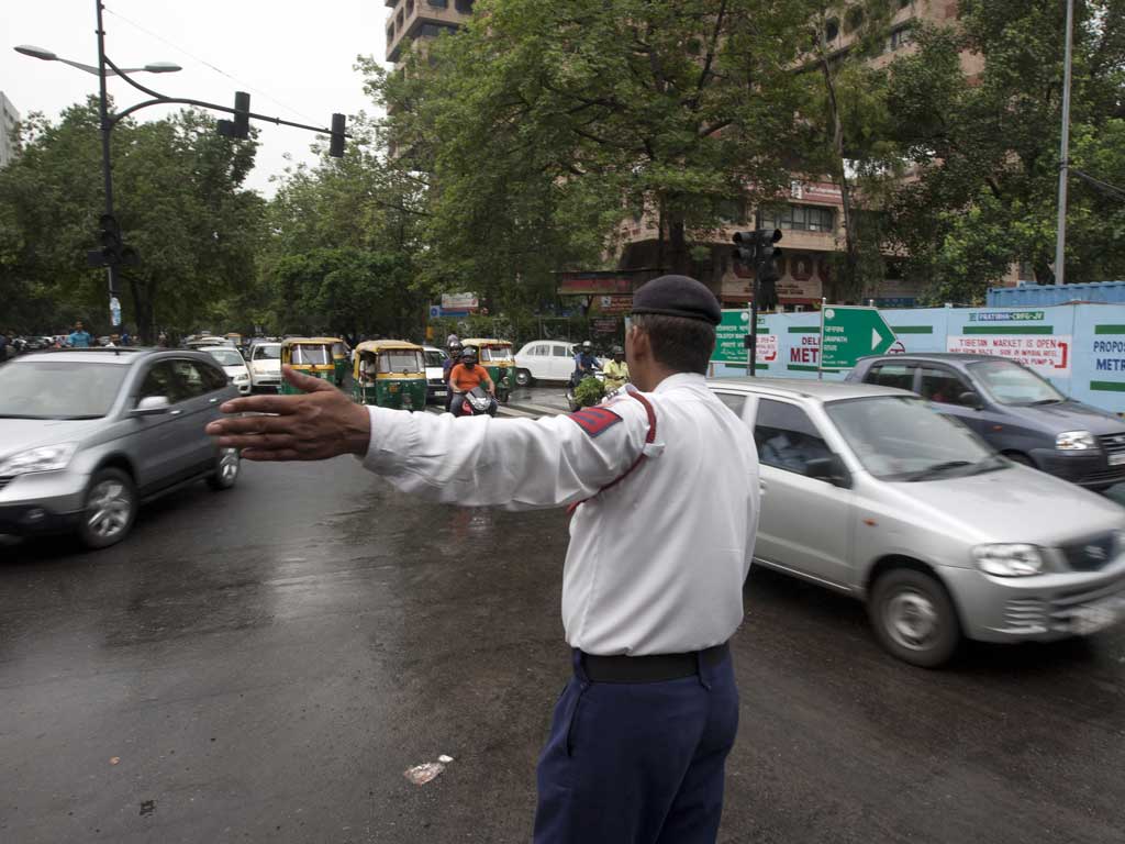An Indian traffic police officer directs traffic at an intersection during a power outtage in New Delhi