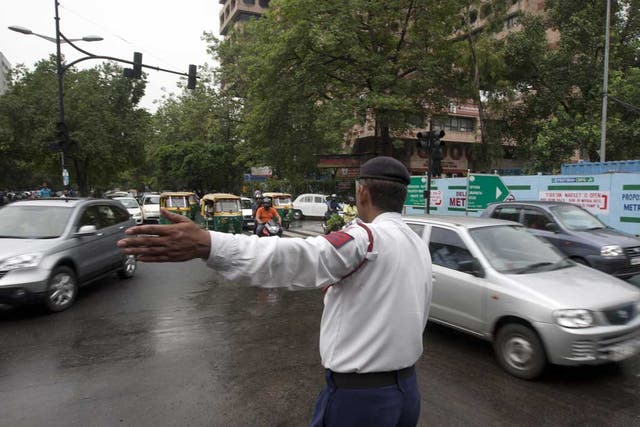An Indian traffic police officer directs traffic at an intersection during a power outtage in New Delhi