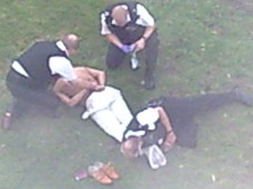 A photograph of Sean Rigg being restrained by police officers
