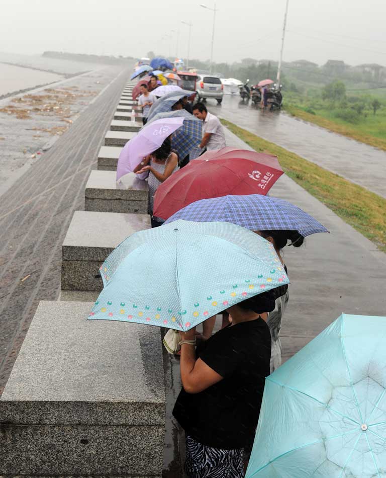 A group of Chinese residents takes shelter along the seafront in Haining as they try to catch a glimpse of incoming Typhoon Saola