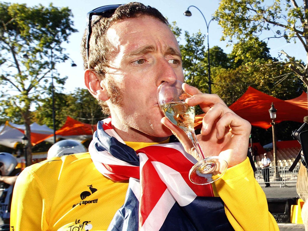 You've earnt that! Bradley Wiggins swigs a loosener at the end of the Tour de France