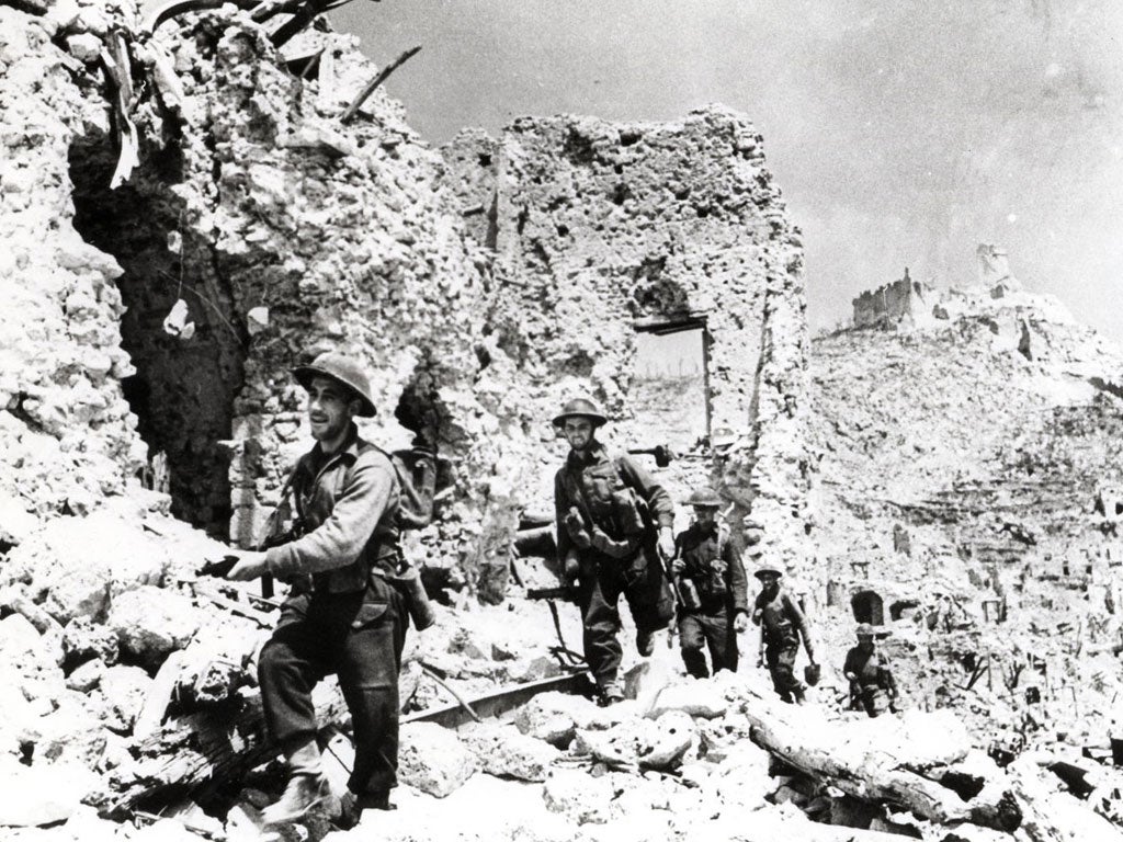 Allied troops pick their way through the shattered town of Cassino