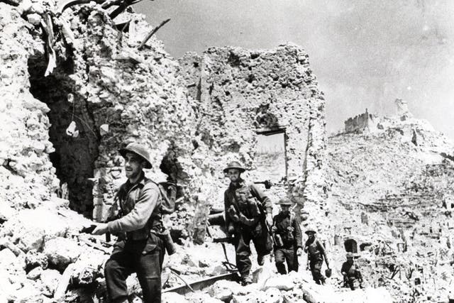 Allied troops pick their way through the shattered town of Cassino