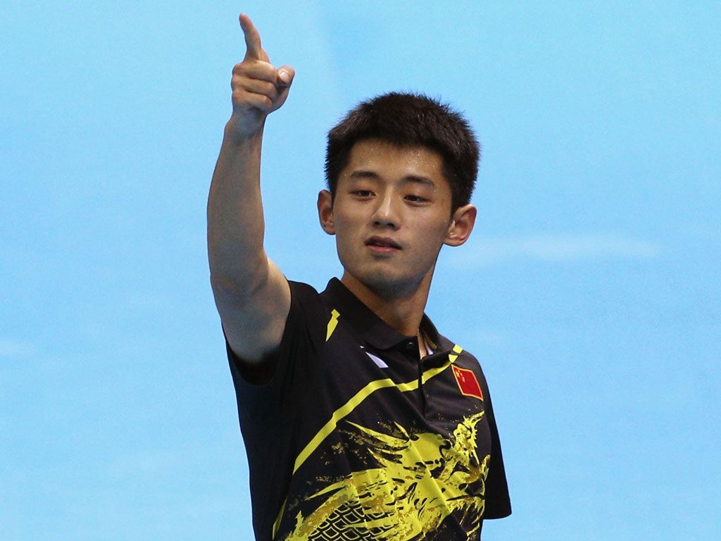 Zhang, the 24-year-old reigning world champion, celebrated by leaping over the court surround and kissing the gold medal podium and then draping himself in a Chinese flag