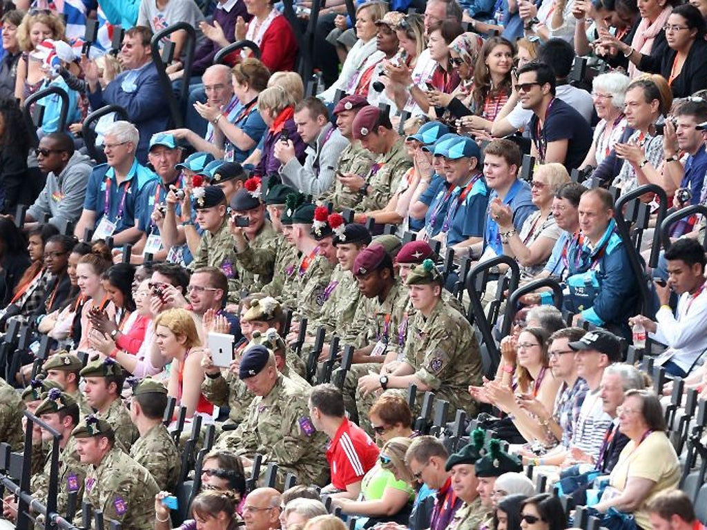Soldiers sat with spectators watch as Great Britain's Jessica Ennis competes in heat 5 of the 100metre hurdles in the first event of the Heptathlon