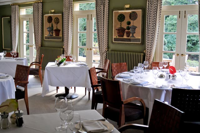 The dining-room is formal, with large, well-spaced tables and taupe-teal walls
