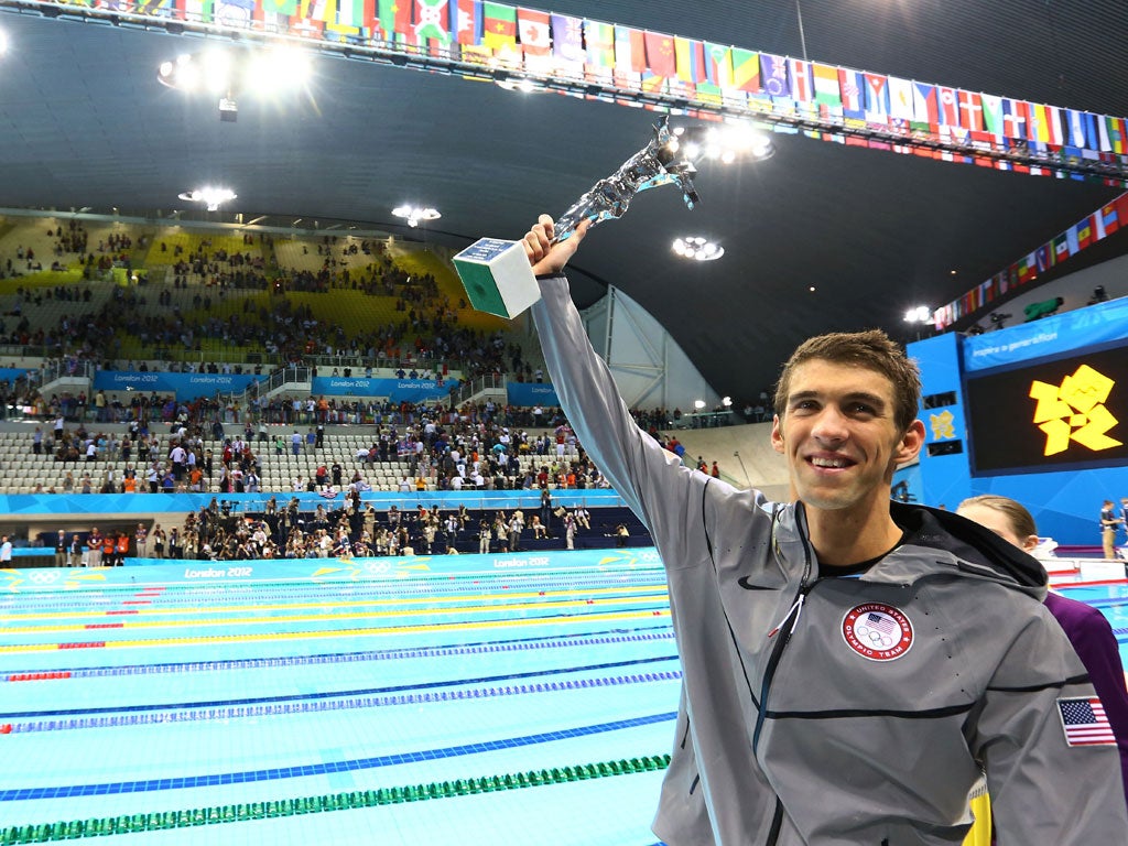 Trophy life: Michael Phelps hoists a special award presented by FINA for his career achievements last night