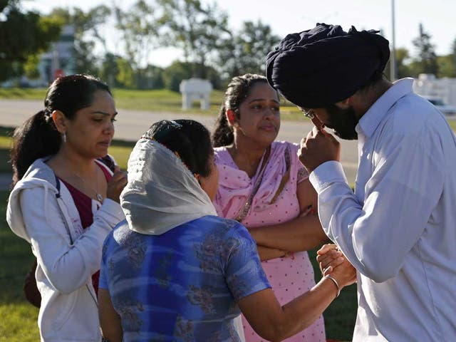 Worshippers console each other near the Sikh Temple of Wisconsin where six people were shot dead in 2012