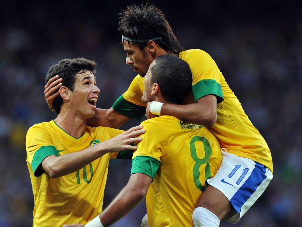 August 7, 2012: Oscar (left) and Neymar (right) congratulate the opening goalscorer of Brazil's semi-final against South Korea, Romulo