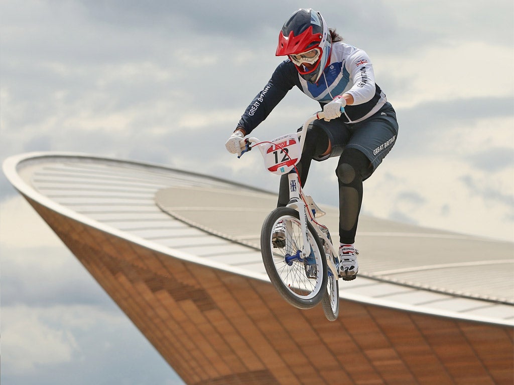 Shanaze Reade trains on the BMX track with the Velodrome in the background yesterday