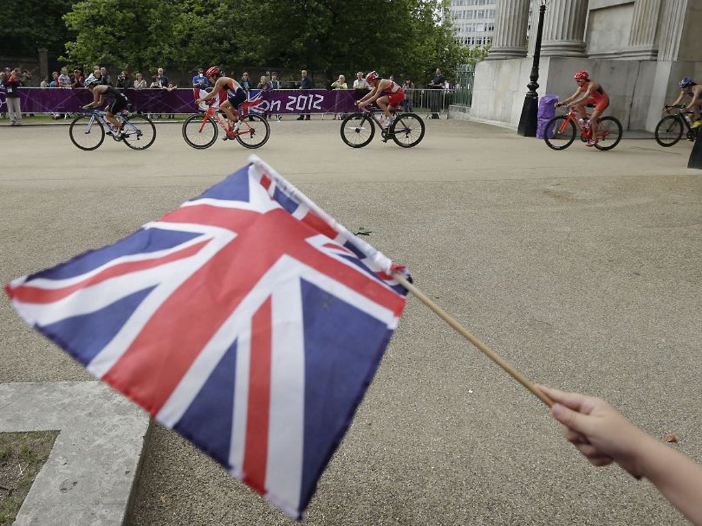 4 August: A boy waves the GB flag as riders pass through Wellington Arch during the women's triathlon