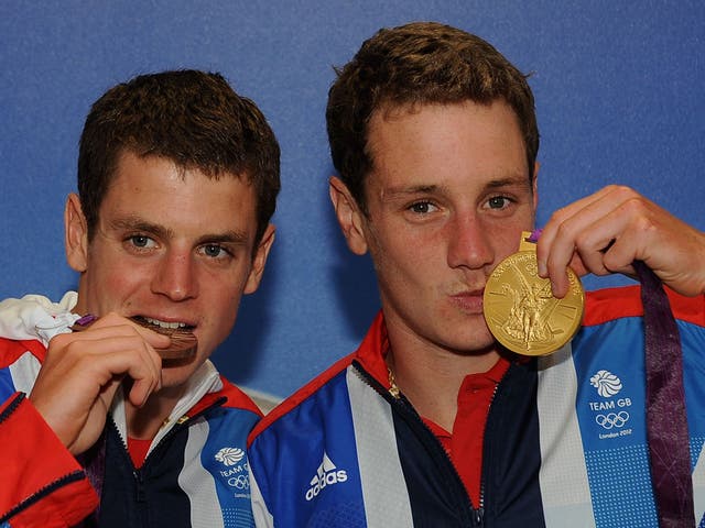 Jonathan Brownlee, left, celebrates his bronze medal while his brother Alistair shows off his gold