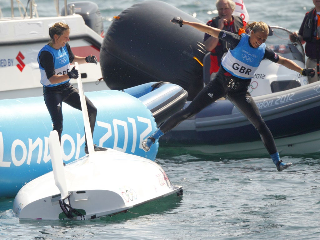 Saskia Clark takes a celebratory dip as Hannah Mills looks on