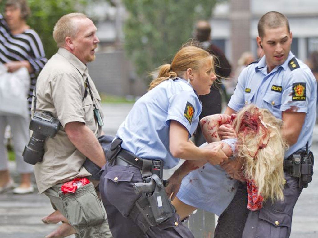 Police help a victim of Anders Breivik’s Oslo bombing last year