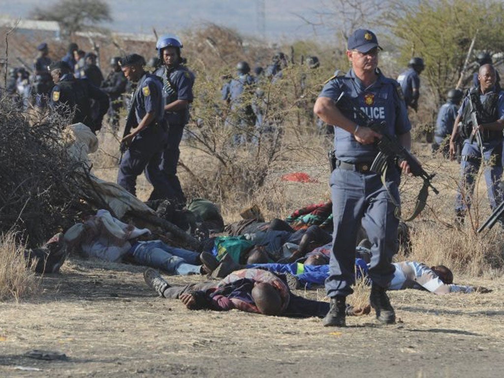 Police surround the bodies of striking miners after opening fire on a crowd at the Lonmin Platinum Mine near Rustenburg