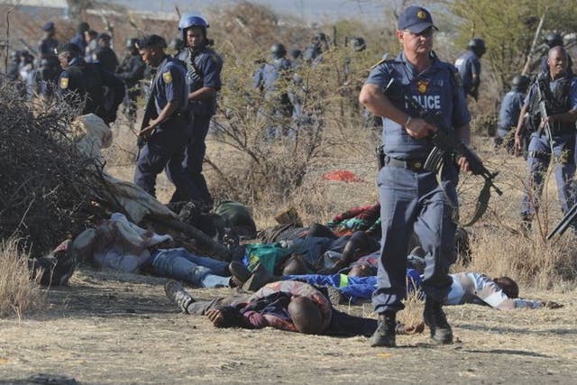 Police surround the bodies of striking miners after opening fire on a crowd  at the Lonmin Platinum Mine near Rustenburg
