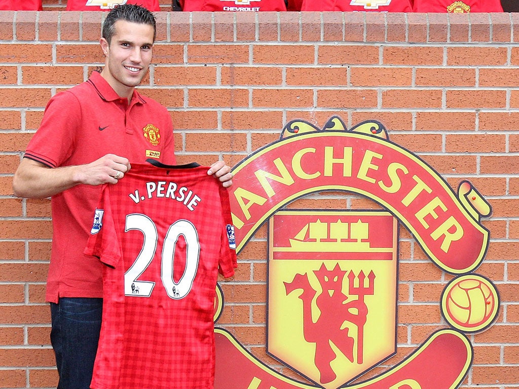 A delighted Robin van Persie poses with his new Manchester
United shirt