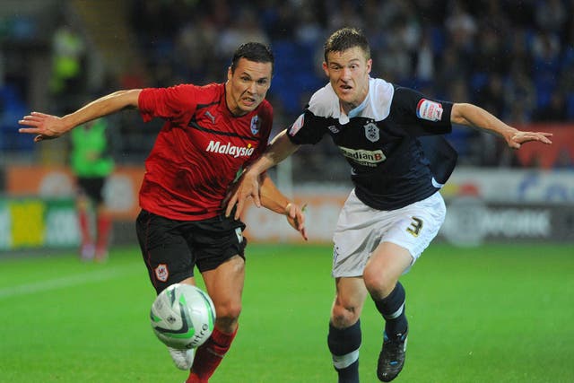 Cardiff's Don Cowie (left) in their controversial red kit and Huddersfield full-back Paul Dixon battle for the ball