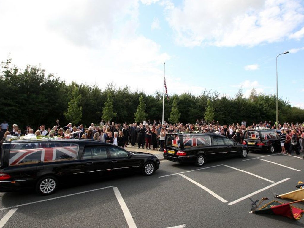 Friends and family lay flowers on the hearses of Lieutenant Andrew Robert Chesterman, Lance Corporal Matthew Smith and Guardsman Jamie Shadrak in Carterton, Oxfordshire
