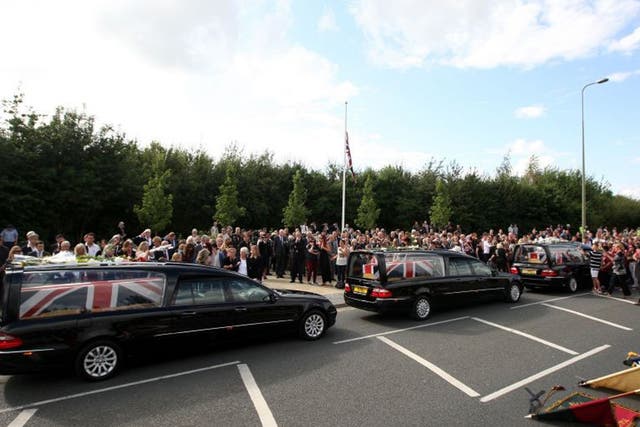 Friends and family lay flowers on the hearses of Lieutenant Andrew Robert Chesterman, Lance Corporal Matthew Smith and Guardsman Jamie Shadrak in Carterton, Oxfordshire