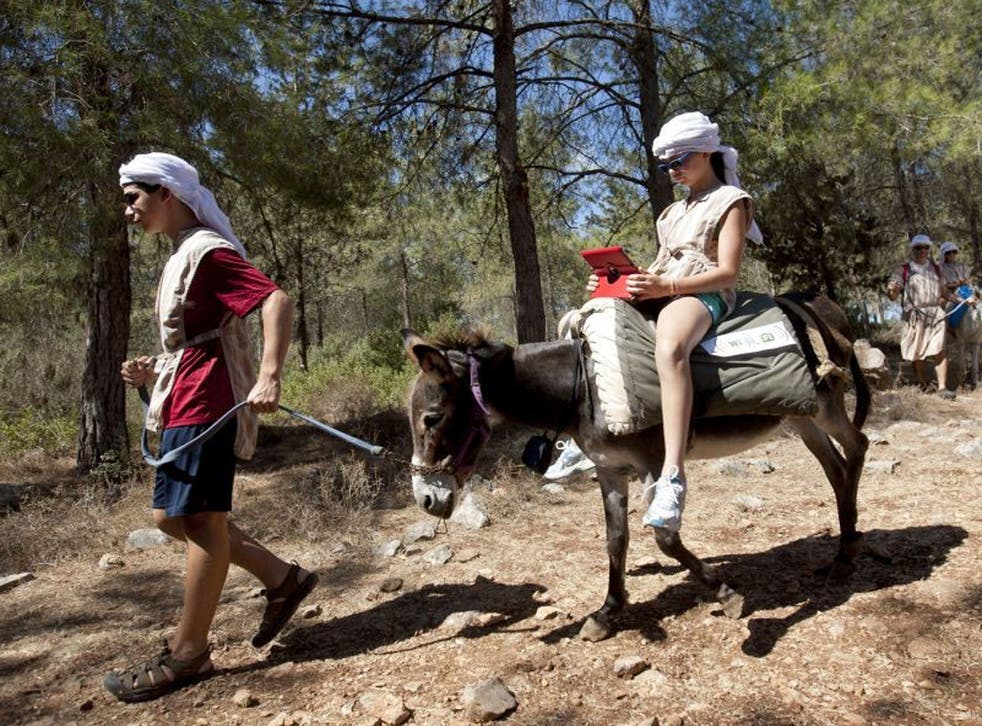 American tourist Ella uses an iPad while riding a Wi-Fi-outfitted donkey